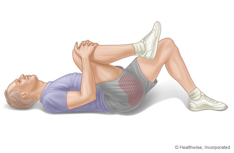 Person performing knee to chest stretch for sciatica pain
